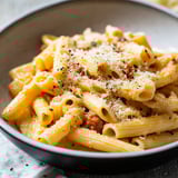 A bowl of pasta with cheese and meat.