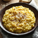 A bowl of pasta with cheese and herbs.