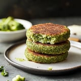 A stack of two pancakes with green stuff on top.
