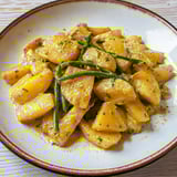 Una tavolata con una porzione di patate e verdure.
